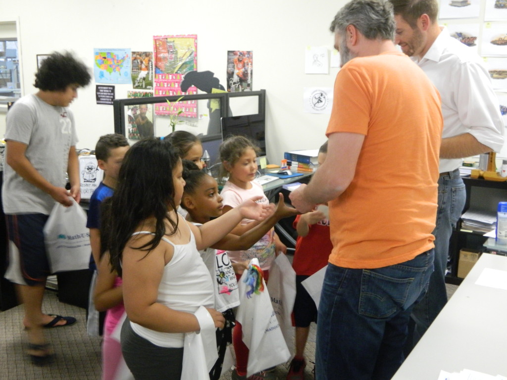 Justin, our design manager (in orange) and I  handing out pencils